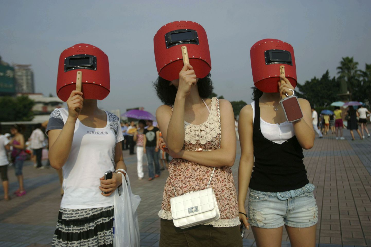 Жительницы Китая наблюдают солнечное затмение 22 июля 2009 года.