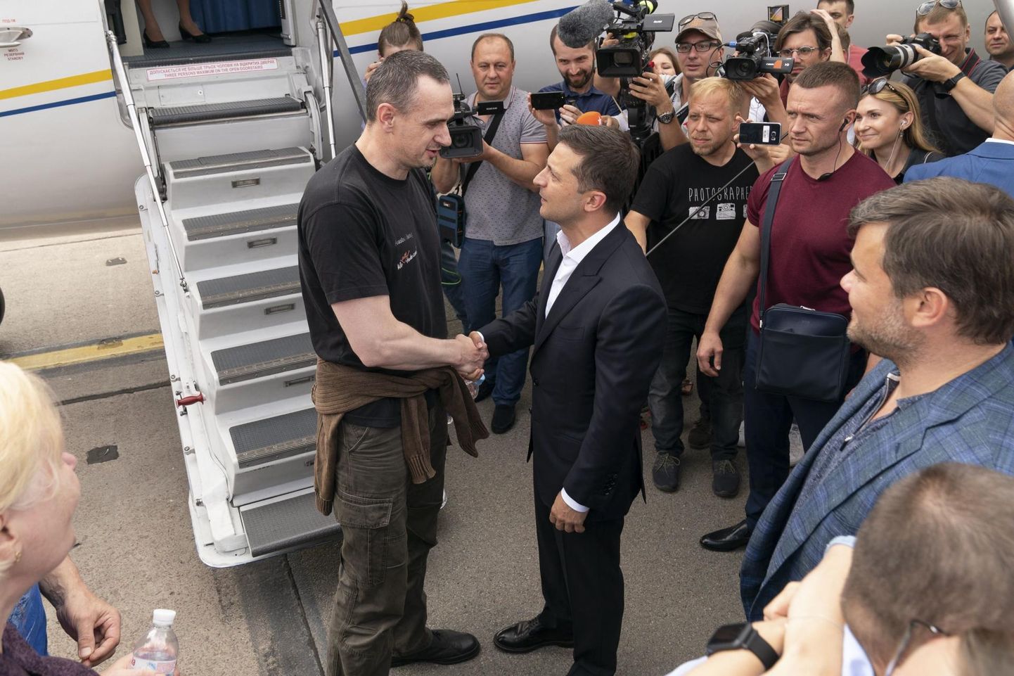 Ukraina president Volodõmõr Zelenskõi (paremal) surumas kätt vangistusest vabanenud režissööri Oleg Sentsoviga.