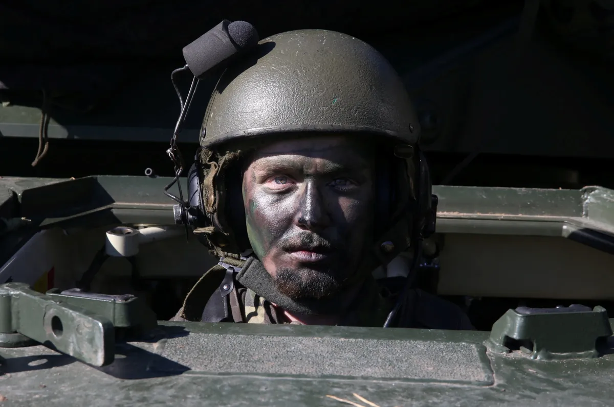 A Swedish soldier sits in an armoured vehicle after a military display during the visit of Latvia's Defense Minister Andris Spruds to a military base in Revingehed, Sweden, October 4, 2024.