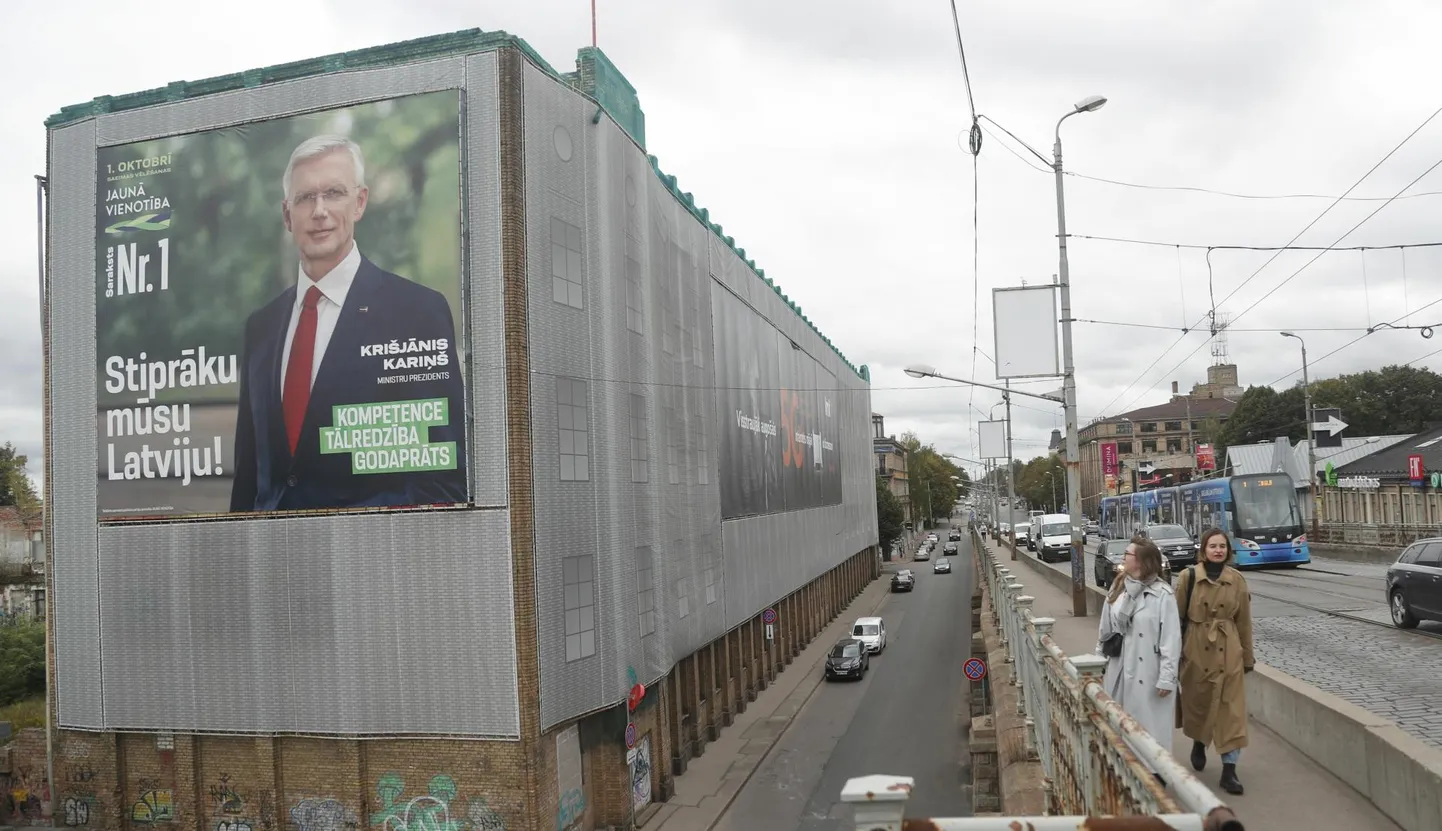 Peaminister Krišjānis Kariņši ja Uue Ühtsuse valimisplakat Riias.

 foto: Toms Kalnins / EPA / Scanpix