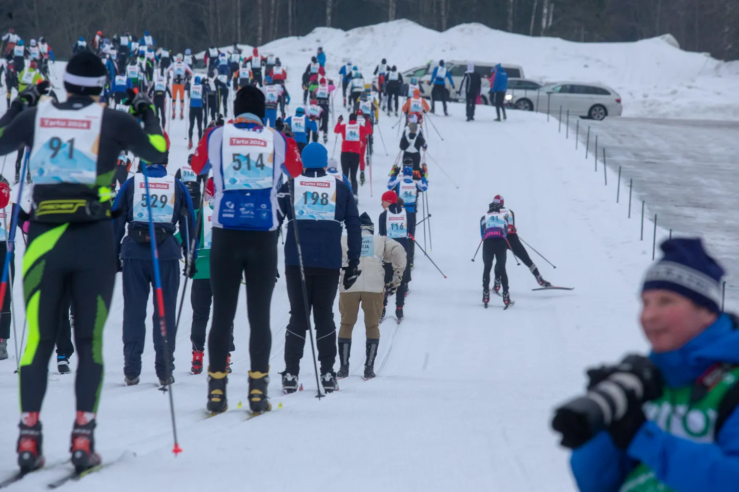 Tartu maratoni programm on äsja saanud avapaugu, kui stardipauk kõlas nii Tartu teatemaratoni kui ka avatud raja sõitudele. Retrorõivais on taamal näha ülejäänud massist eralduvat puusuuskadega Tartu maratoni peakorraldajat Indrek Kelku.