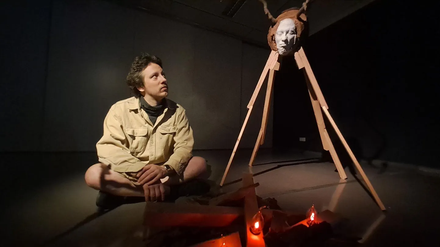 Kunstnik Johannes Luik on loonud Vana-Võromaa galeriisse unenäolise maailma. Pildil istub ta koos omaloodud elukatega lõkke man. FOTO: Arved Breidaks