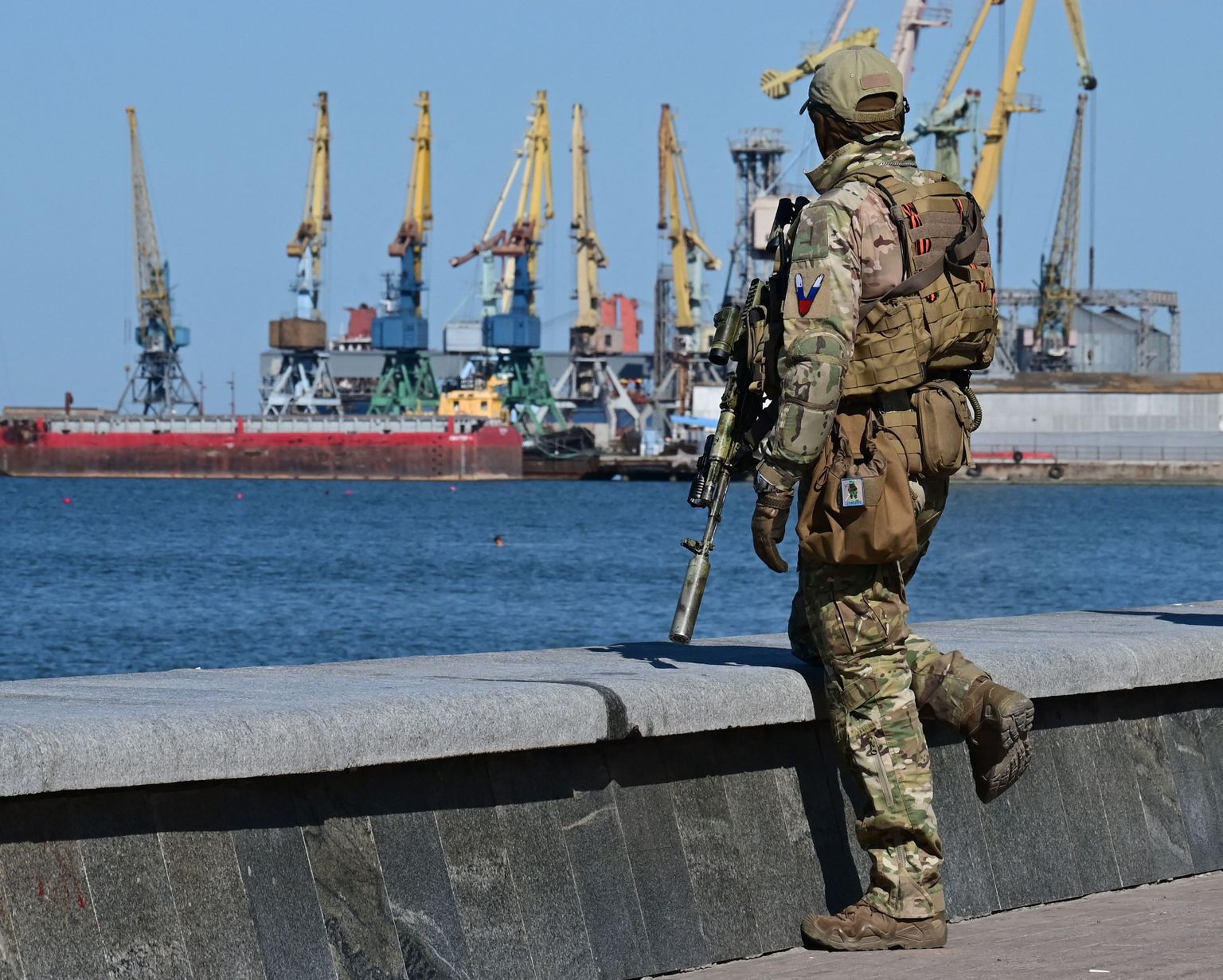 A Russian serviceman patrols on the promenade in Berdyansk, amid the ongoing Russian military action in Ukraine, on June 14, 2022.