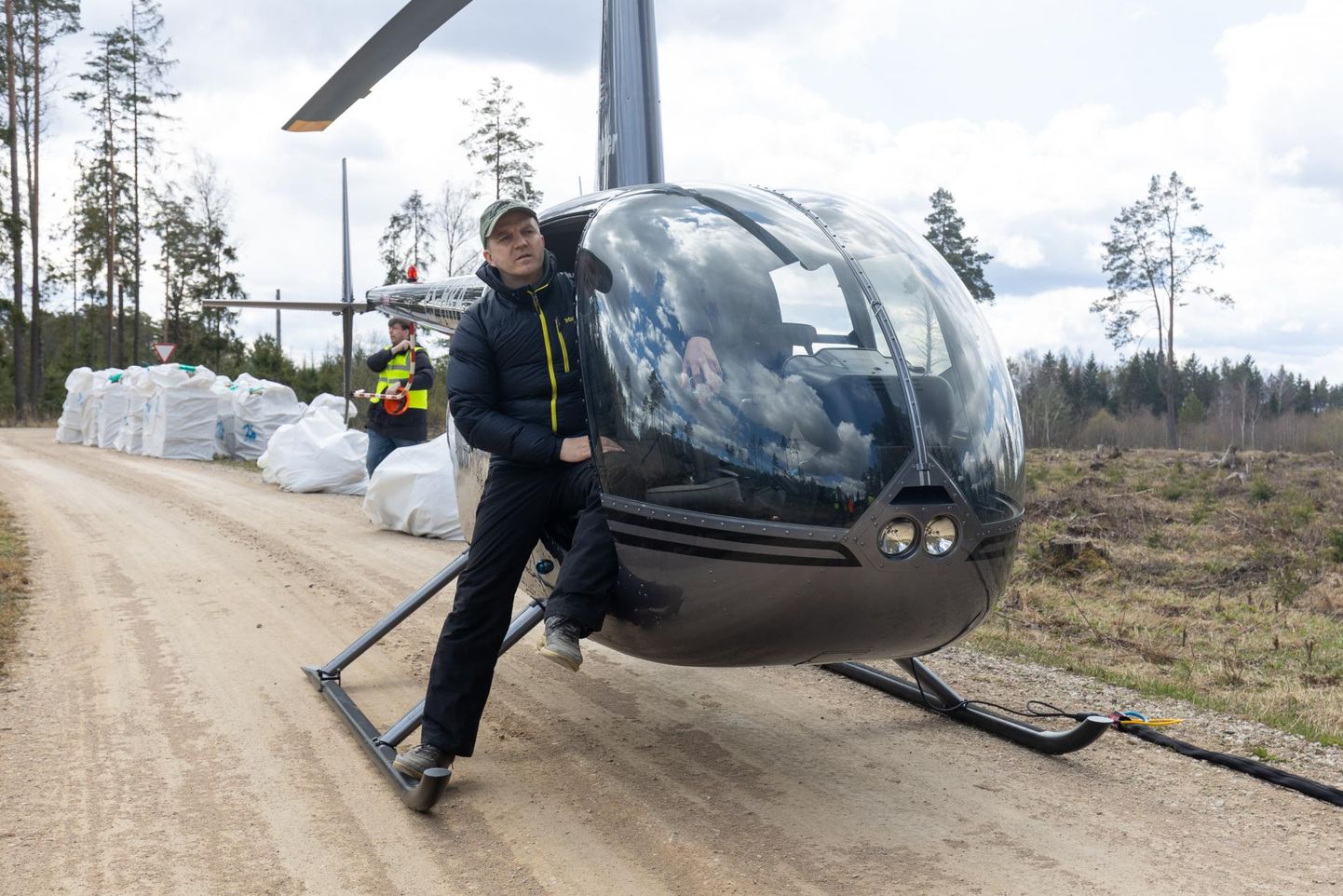 Rene Kallis helikopteri jalasel olukorda takseerimas. Kopteri taga on kotid istikutega.
