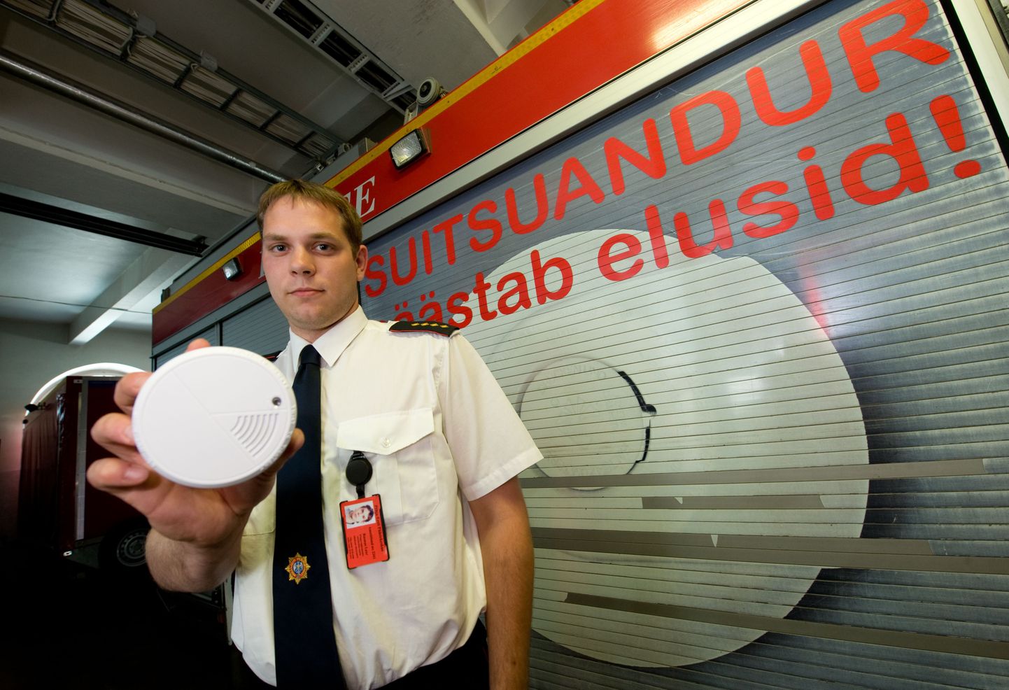 Põha-Eesti päästekeskuse planeerimisbüroo juhtivspetsialist Rasmus Laar demonstreerib suitsuandurit.
