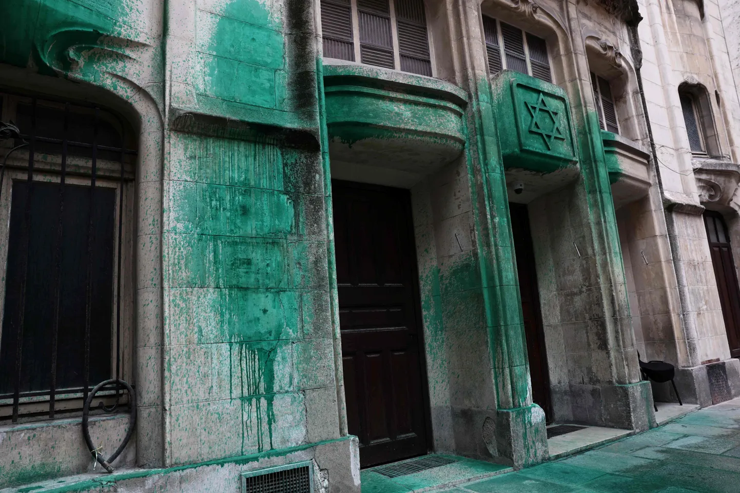 Fotogrāfijā redzams, kā 2025. gada 31. maijā Parīzē uz Agoudas Hakehilos sinagogas sienām uzsmērēta zaļa krāsa. Saskaņā ar policijas avotiem naktī uz 30. maiju ar zaļu krāsu tika apsmidzināti Šoah memoriāls, divas sinagogas un restorāns Parīzes centrā.