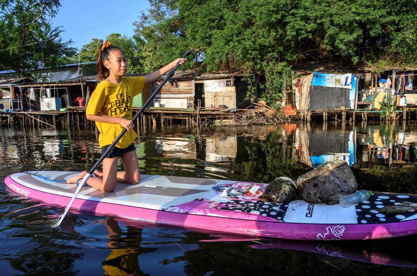 12-aastane Ralyn Satidtanasarn, tuntud oma hüüdnimega Lilly, sõitmas aerulaual Bangkoki kanalil, õngitsedes räpasest veest välja plasträmpsu.