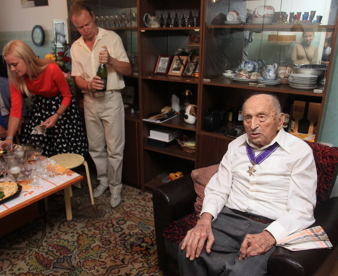 Evald Rooma aasta eest, oma 105. sünnipäeval. Tagaplaanil vasakul avab vahuveinipudelit Priit Tuubel.