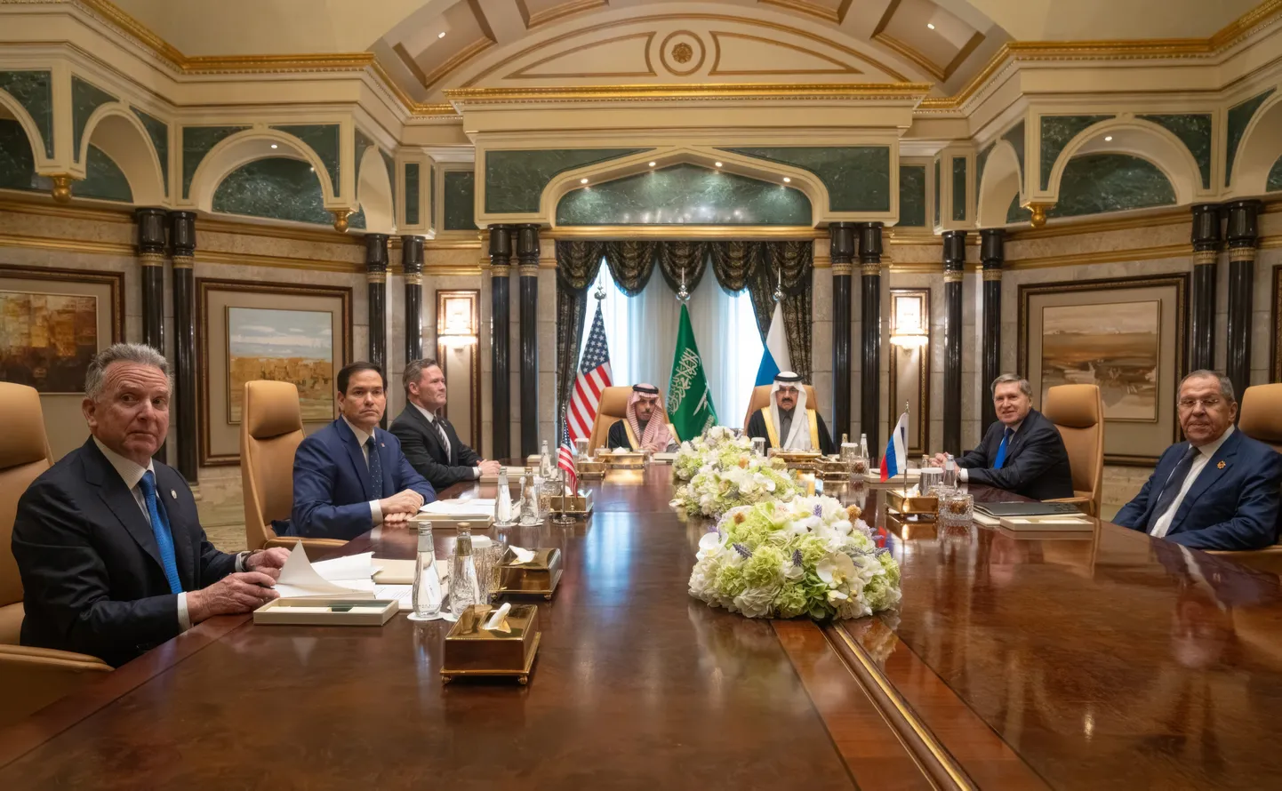 Представители США (слева направо: Стив Уиткофф, Марко Рубио, Майк Уолтц) и России (справа налево: Сергей Лавров, Юрий Ушаков). Во главе стола - министр иностранных дел Саудовской Аравии принц Фейсал бин Фархан Аль Сауд и советник по национальной безопасности Мосаад бин Мохаммед Аль Айбан.