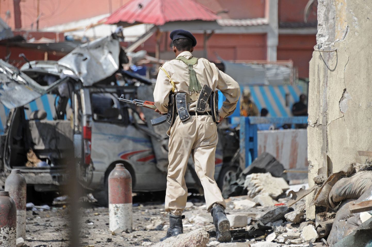 Полицейский рядом с руинами отеля, подвергшегося атаке боевиков "Аш-Шабаб".