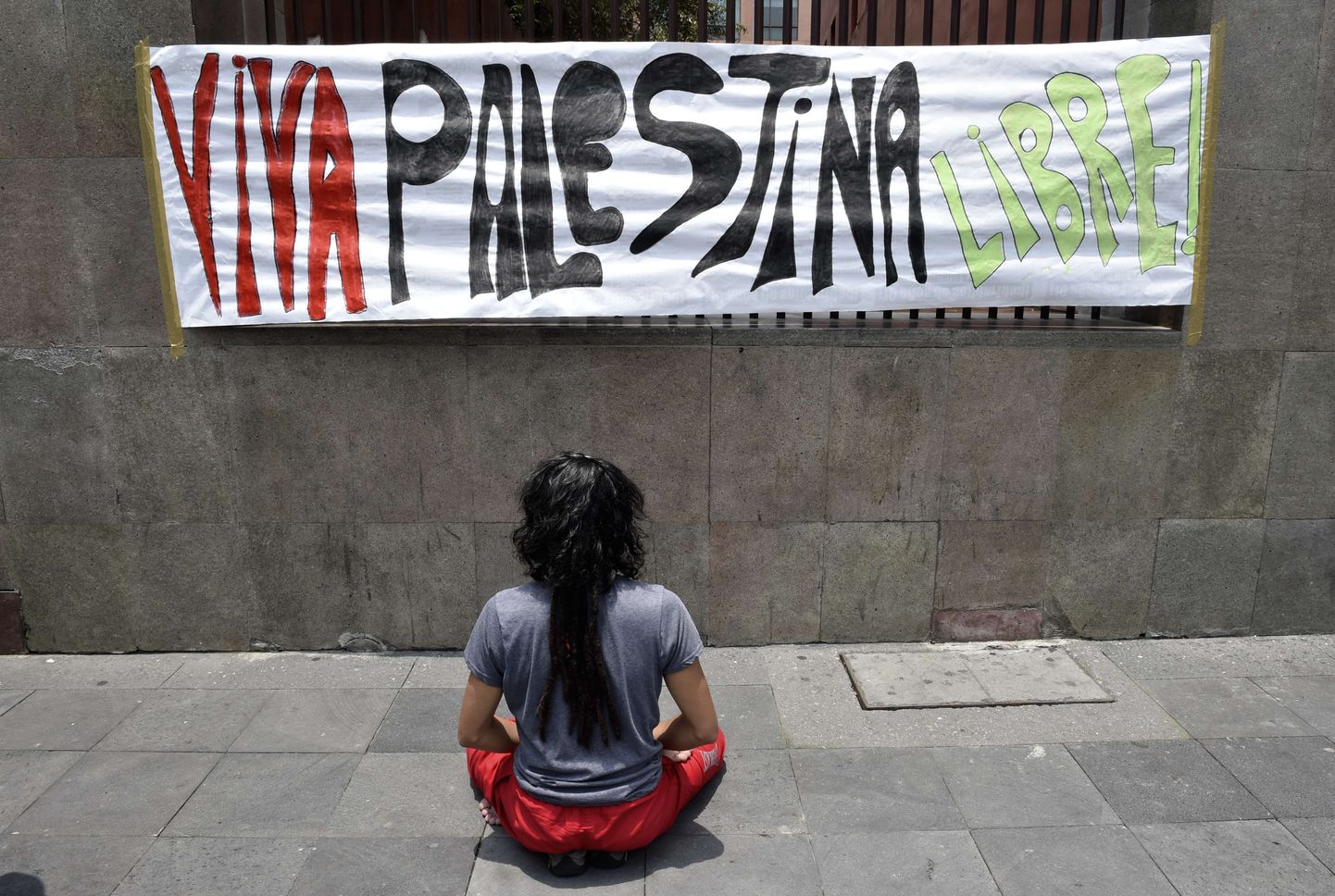 Aktivist palvetab loosungi «Elagu Palestiina vabadus» ees.