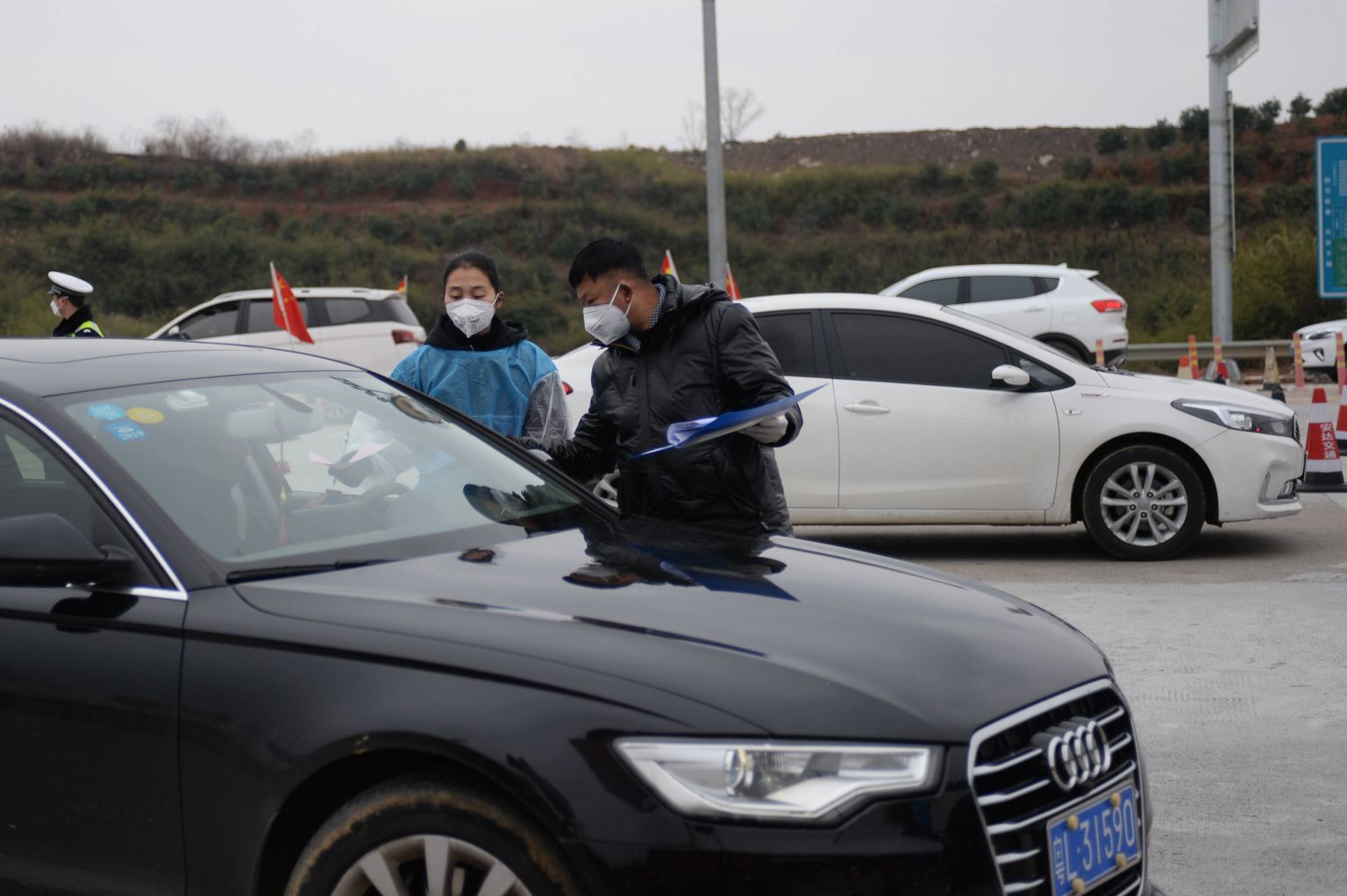Tervishoiutöötajad jagavad koroonaviiruse infolehti Louhuai maantee ääres.