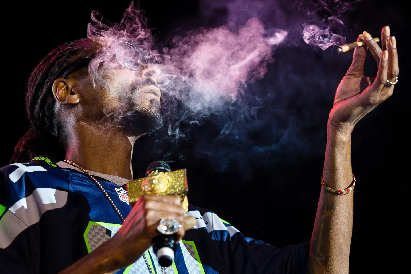 Snoop Dogg exhales lungfuls of blunt smoke on stage during