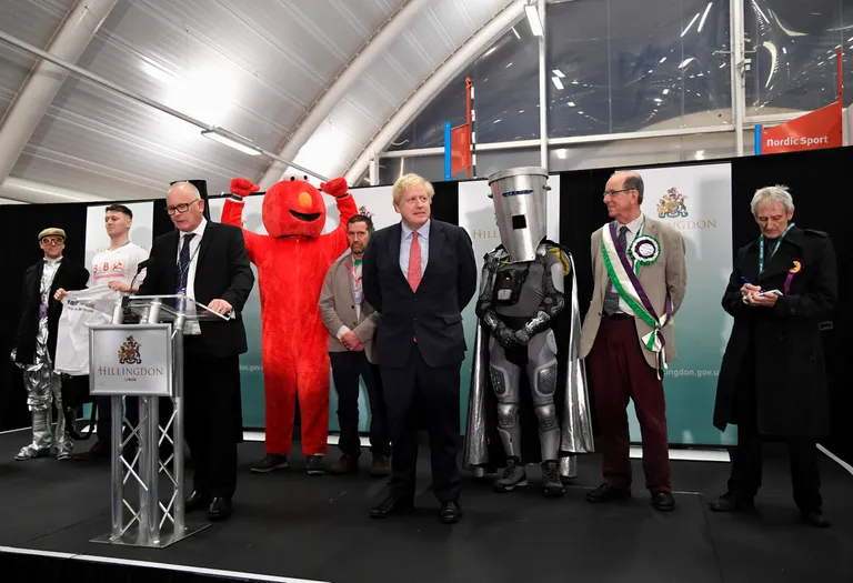 Ühendkuningriigi parlamendivalimistel sai võidu Konservatiivne partei, mille esimees, Briti peaminister Boris Johnson (keskel) pidas võidukõne, seljataga olid tal aga kummalised tegelased.