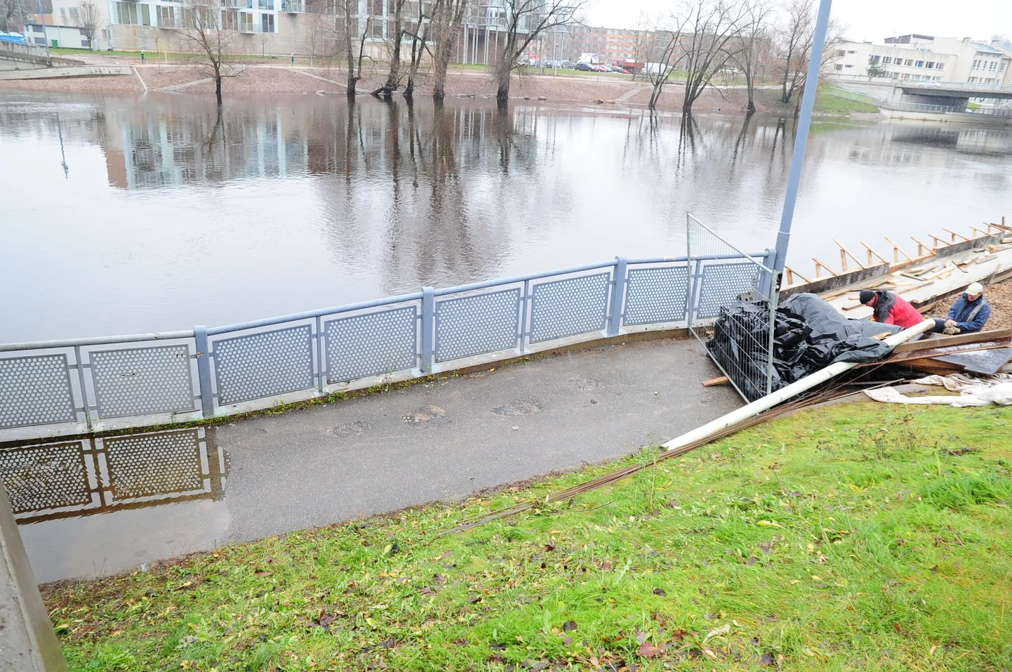Tavti töömehed (paremal) peavad uuendama ka Kroonuaia silla alla viiva kõnnitee, kuid tööd jäävad ilmselt kevadesse, sest jõgi tuleb neile mööda asfaldit vastu.