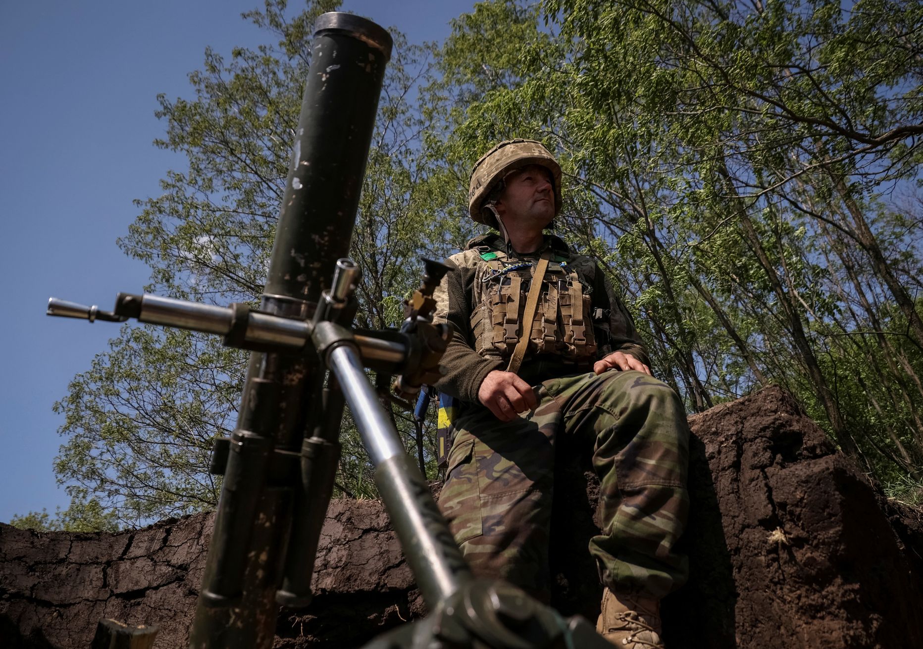 Украинский военнослужащий из 28-й отдельной механизированной бригады имени рыцарей Зимней кампании Вооруженных сил Украины готовится к обстрелу из миномета своих позиций на линии фронта возле Бахмута.