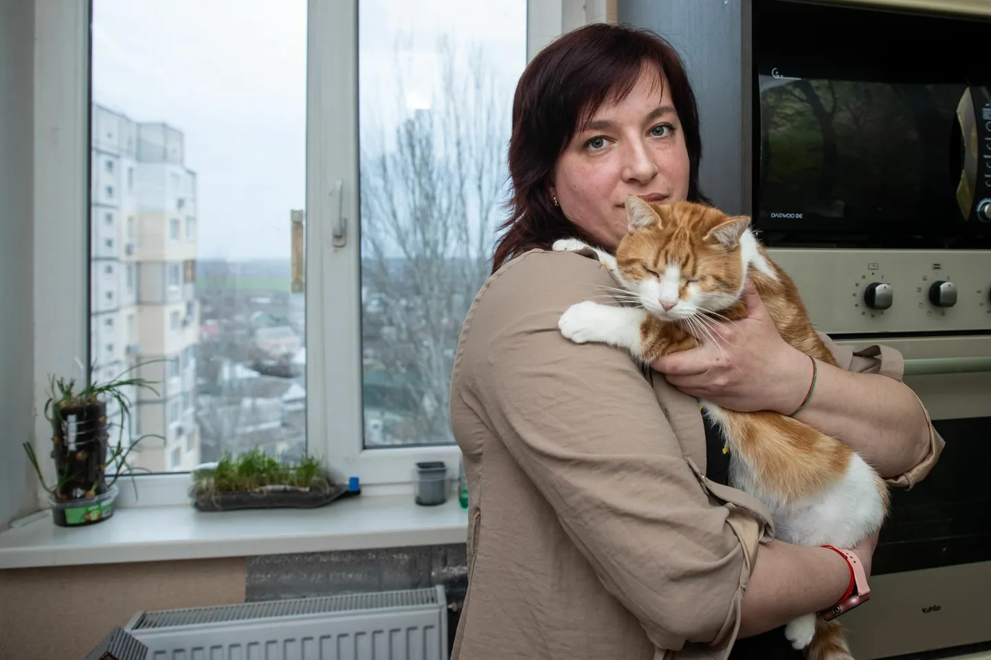 Анастасия в херсонской квартире, которую ей предоставил для проживания уехавший знакомый. На руках она держит слепого кота Феникса, которого она не решилась оставить жить на улице, поскольку он бы там сразу погиб.