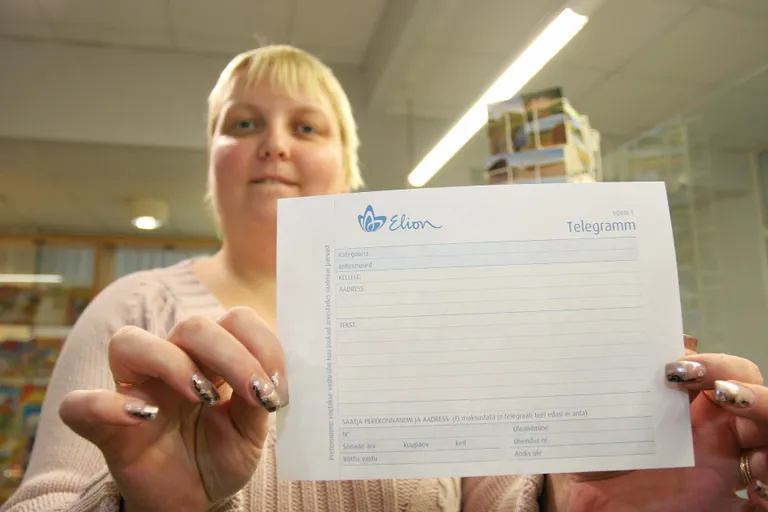 Viljandi postkontori juhataja Dagmar Laanisto näitab minevikku minevat telegrammi blanketti.