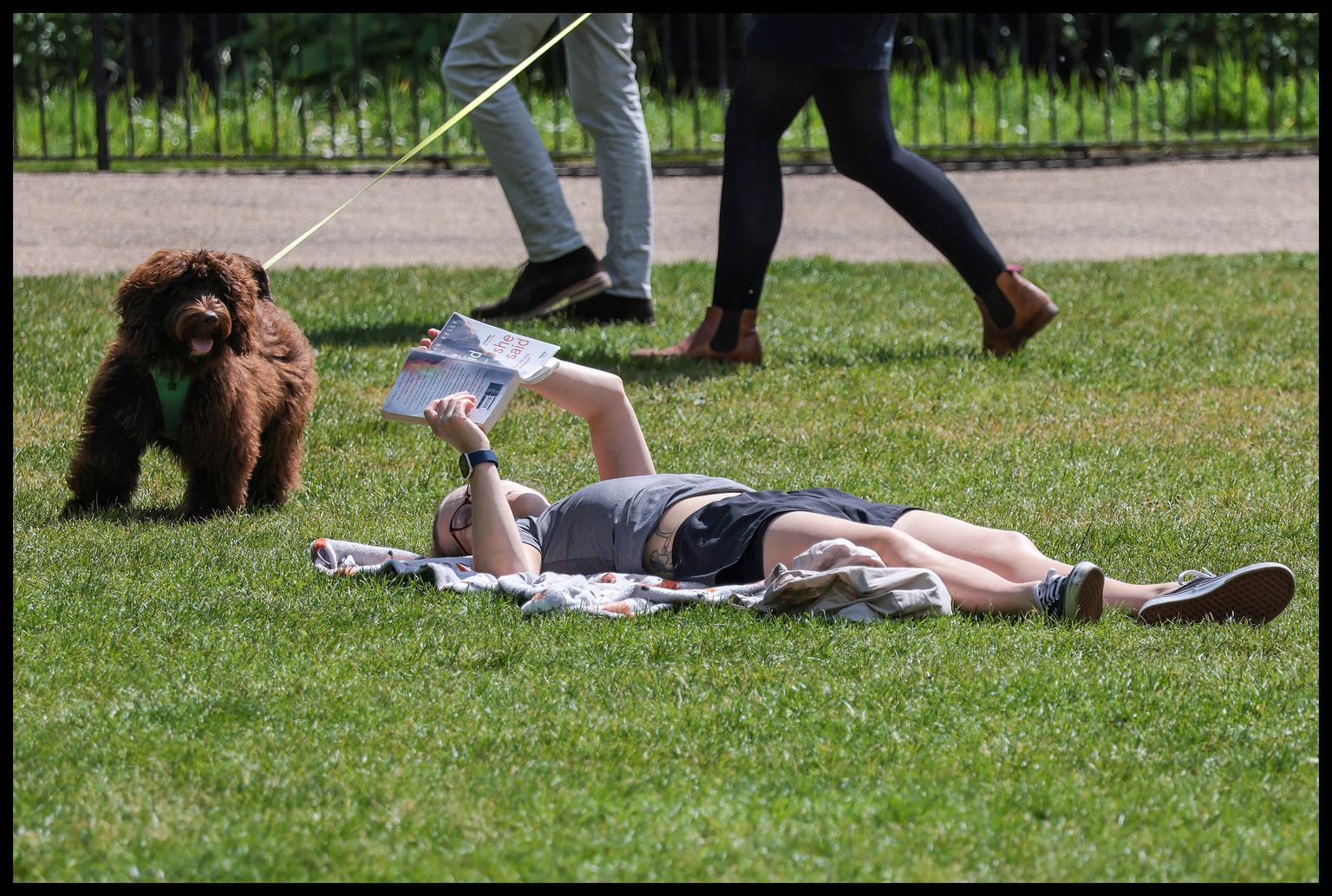 May 12, 2022, London, London, United Kingdom: Image Licensed to i-Images Picture Agency. 12/05/2022. London, United Kingdom. Londoners Enjoy the Sunshine. ..A dog stops to look at a woman reading a book as Londoners and tourists enjoy the sunshine in St James' Park, London. (Credit Image: © Martyn Wheatley/i-Images via ZUMA Press)