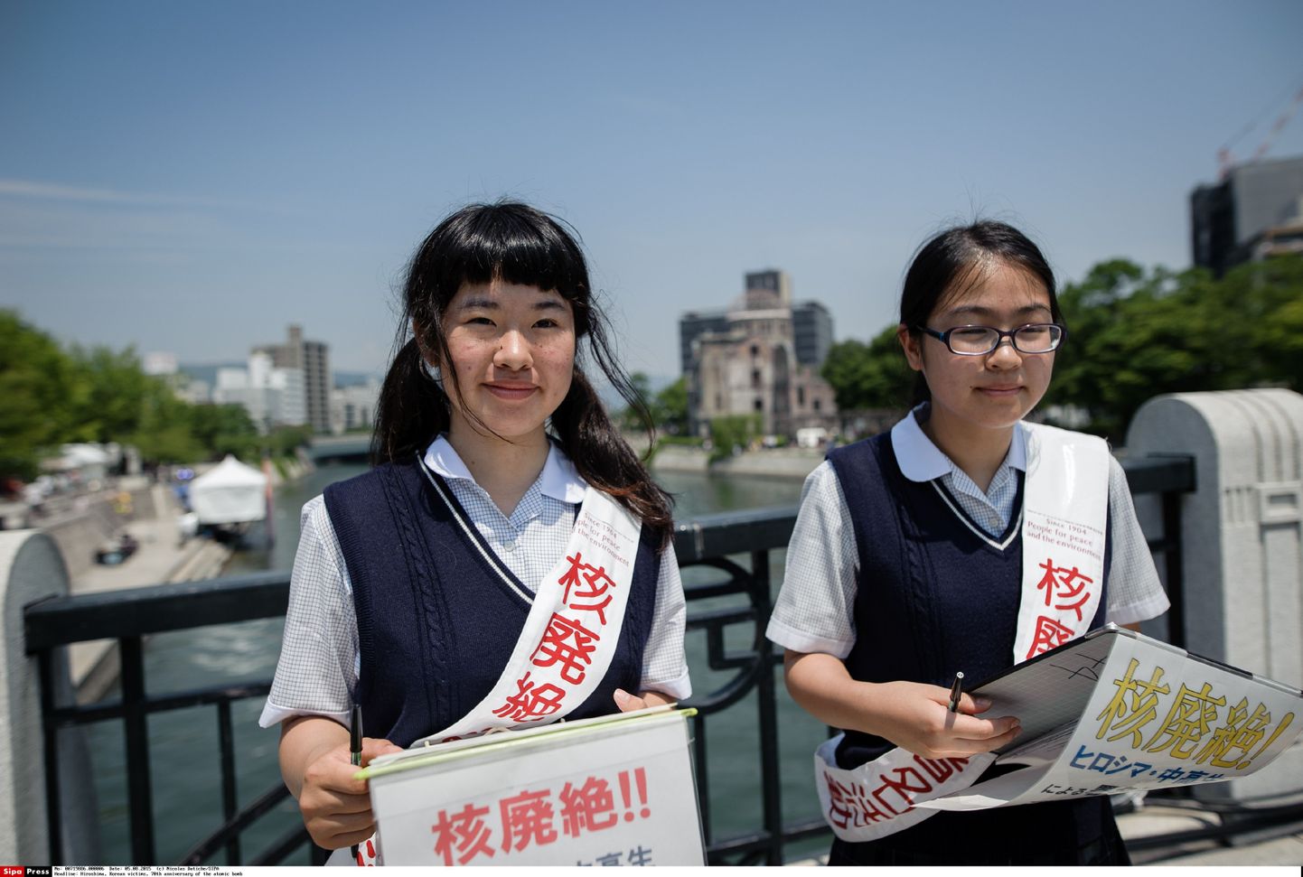 Kaks keskkoolitüdrukut Hiroshima kesklinnas hoidmas loosungeid, millega nõuavad tuumarelvade vastase sildi püstitamist.