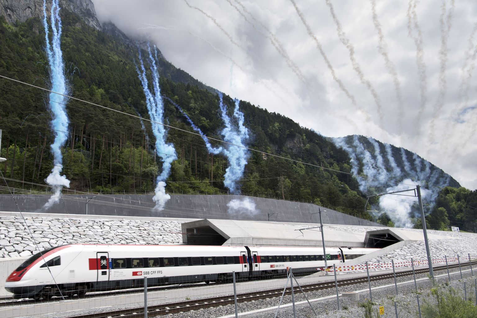 The first train comes out of the tunnel's North portal on the opening day of the Gotthard rail tunnel,  at the North portal near Erstfeld, Switzerland, Wednesday, June 1, 2016. The construction of the 57 kilometer long tunnel began in 1999, the breakthrough was in 2010. After the official opening on June 1, the commercial operation will begin in  December 2016. (Laurent Gillieron/Keystone via AP)