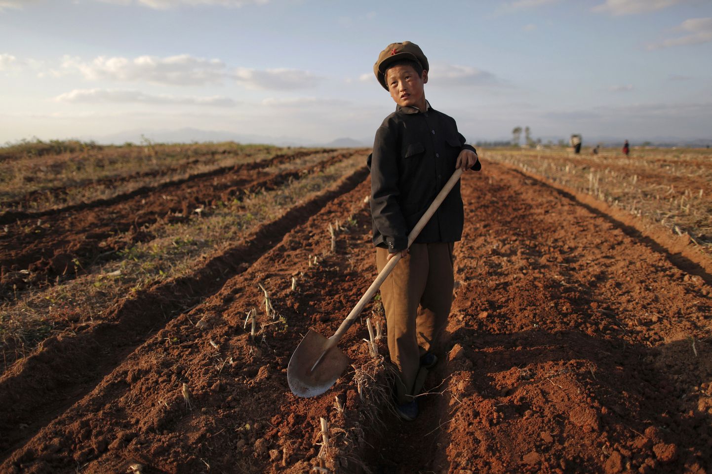 EDITORS NOTE: PICTURES TAKEN ON A GOVERNMENT CONTROLLED TOUR FOR REUTERS ALERTNET 
A North Korean boy works in a field of a collective farm in the area damaged by summer floods and typhoons in South Hwanghae province, in this September 30, 2011 file photo.  North Korea plans to allow farmers to keep more of their produce in an attempt to boost agricultural output, a source with close ties to Pyongyang and Beijing said, in a move that could boost supplies, help cap rising food prices and ease malnutrition. The move to liberalise agriculture under new leader Kim Jong-un, who took office in December 2011 after the death of his father, would reverse a crackdown on private production that started in 2005. It comes amid talk that the youngest Kim to rule the impoverished North is considering reforms to boost the economy. REUTERS/Damir Sagolj/Files   (NORTH KOREA - Tags: AGRICULTURE HEALTH SOCIETY POVERTY BUSINESS)