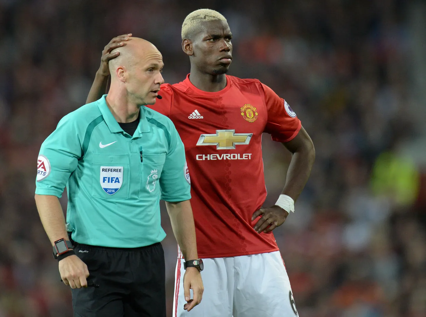 Kohtunik Anthony Taylor (vasakul) ja Manchester Unitedi poolkaitsja Paul Pogba.