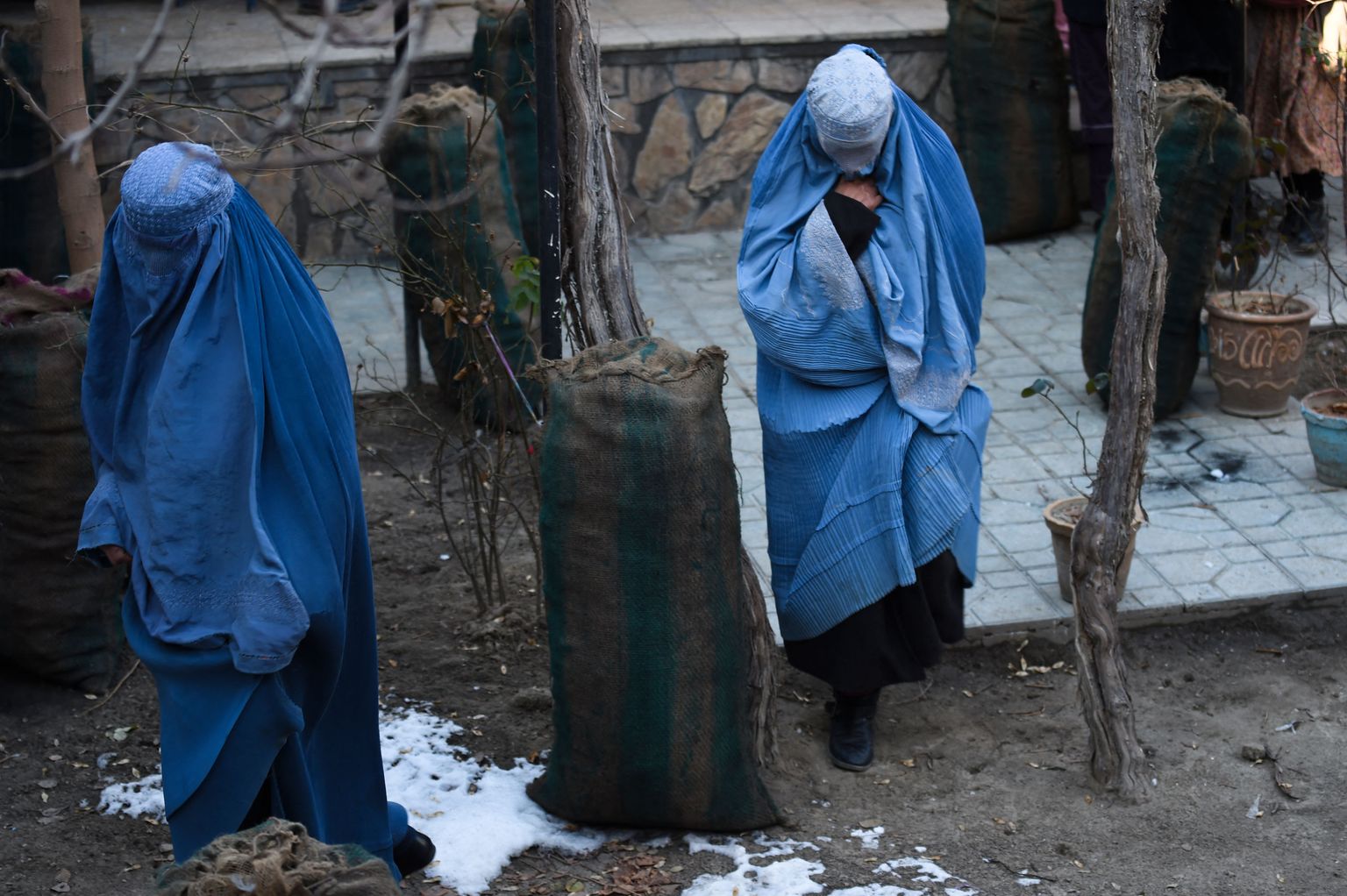Naised Kabulis vabatahtlike poolt jagatud söekotiga.