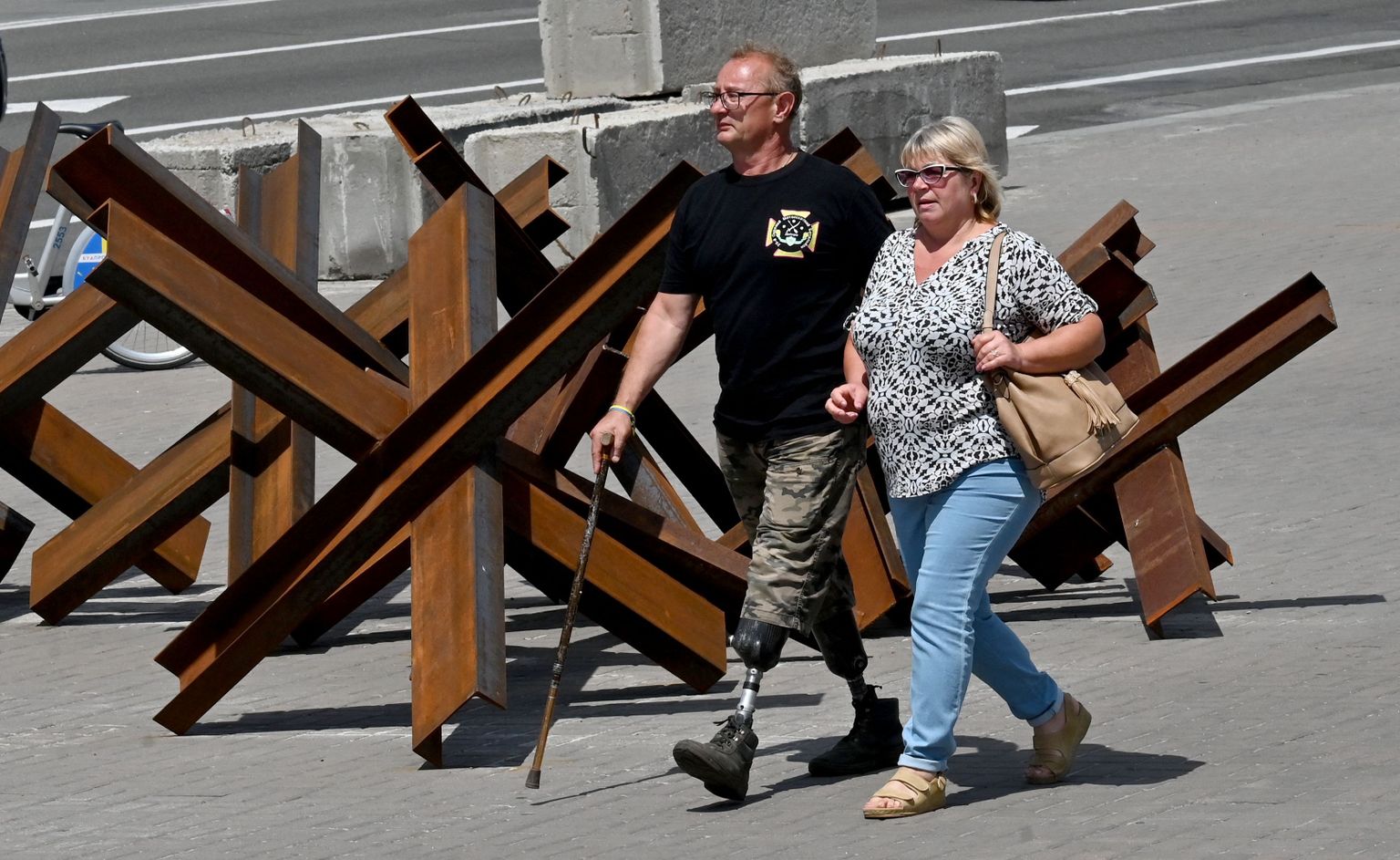 Ветеран войны с Россией потерявший обе ноги на фронте проходит мимо противотанковых ежей в центре Киева, июнь 2022 года