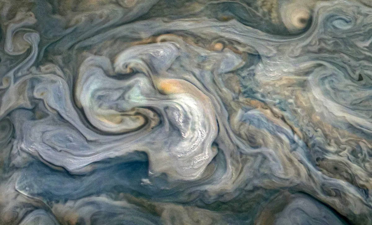 Ar NASA kosmosa kuģi “Juno” uzņemtās Jupitera mākoņu virsotnes. Mazie, gaišie mākoņi attēla centrā atrodas augstāk virs Jupitera, bet tumšākās vietas - zemāk.