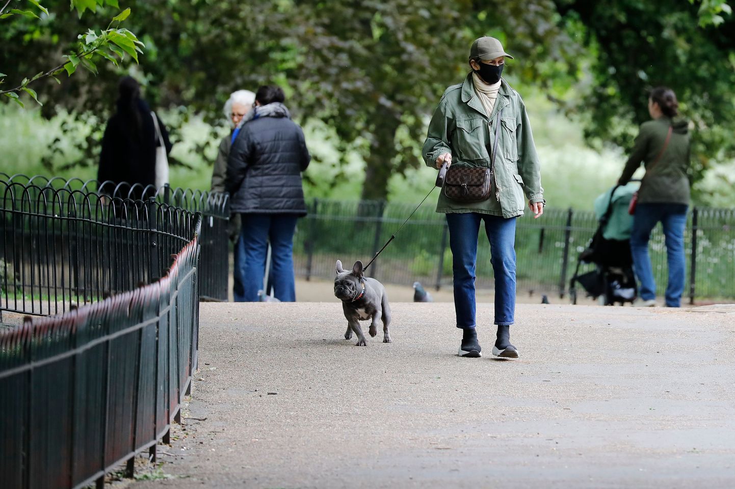 Sieviete staidzina suni parkā Londonā. Ilustratīvs attēls