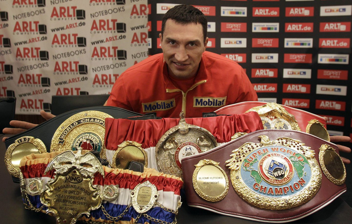 Vladimir Klitško pressikonverentsil oma WBA, IBF, WBO, IBO ja Ring Magazine'i meistrivöösid demonstreerimas.
