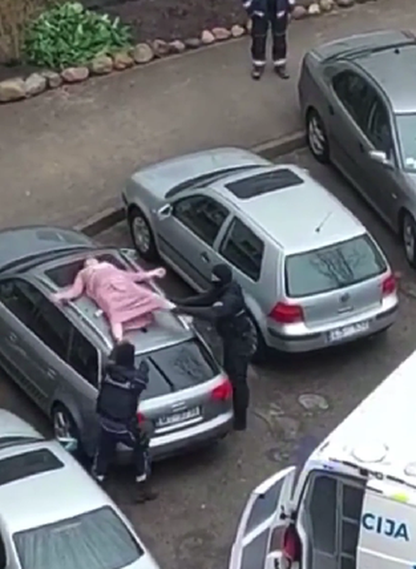 Женщина на крыше автомобиля в Риге. Кадр из видео с Facebook.