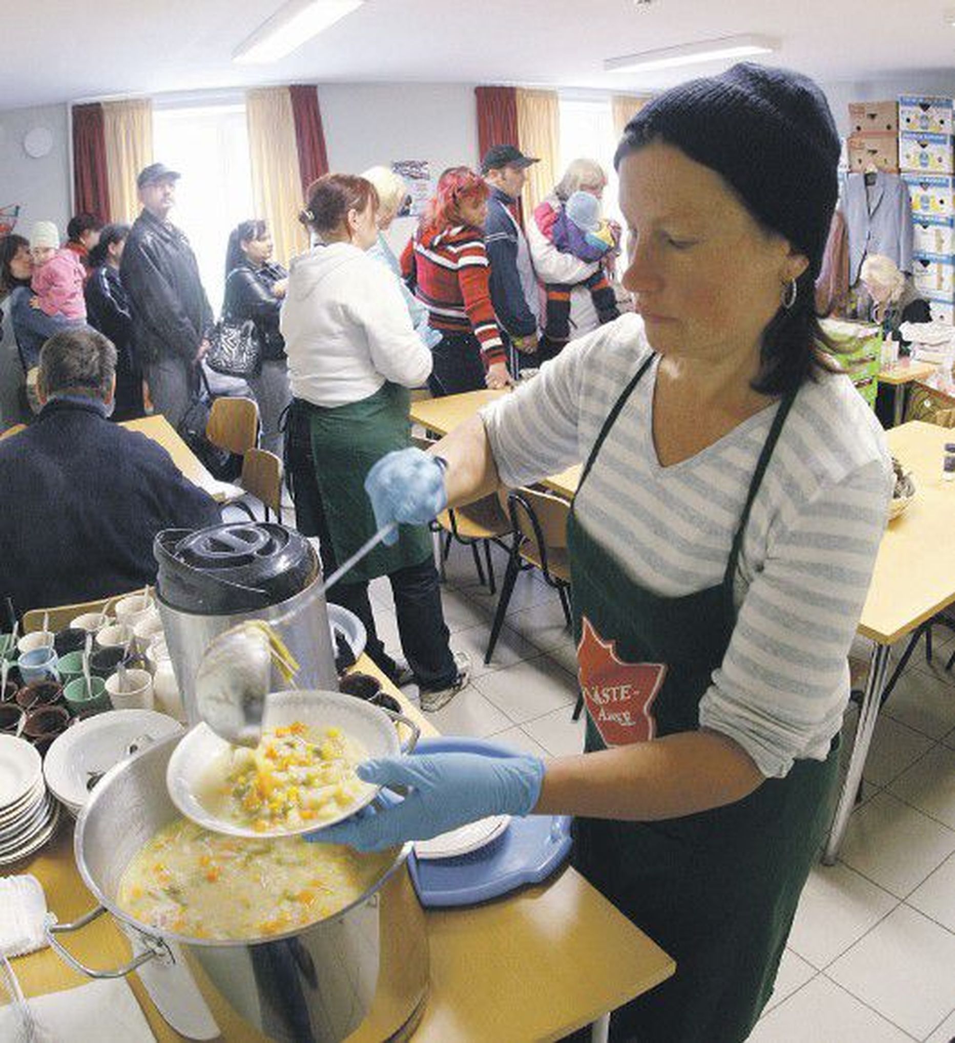 Eile hommikul tõstis suurest potist kalasuppi Päästearmee Tartu korpuse vabatahtlik Aino Lükko. Tagapool seisid järjekorras toiduabipakke ootavad inimesed.