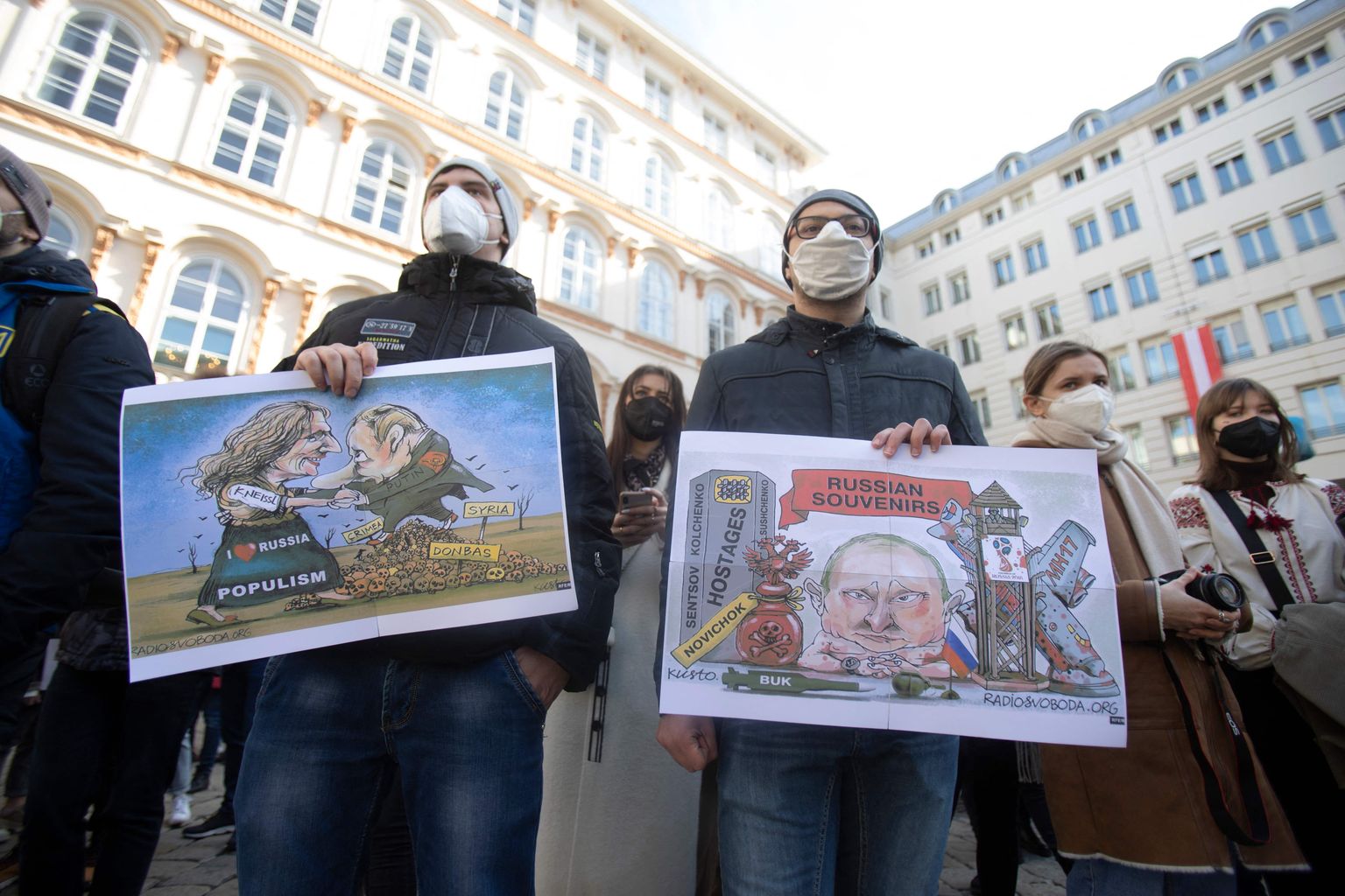 Люди с карикатурами протестуют против войны.