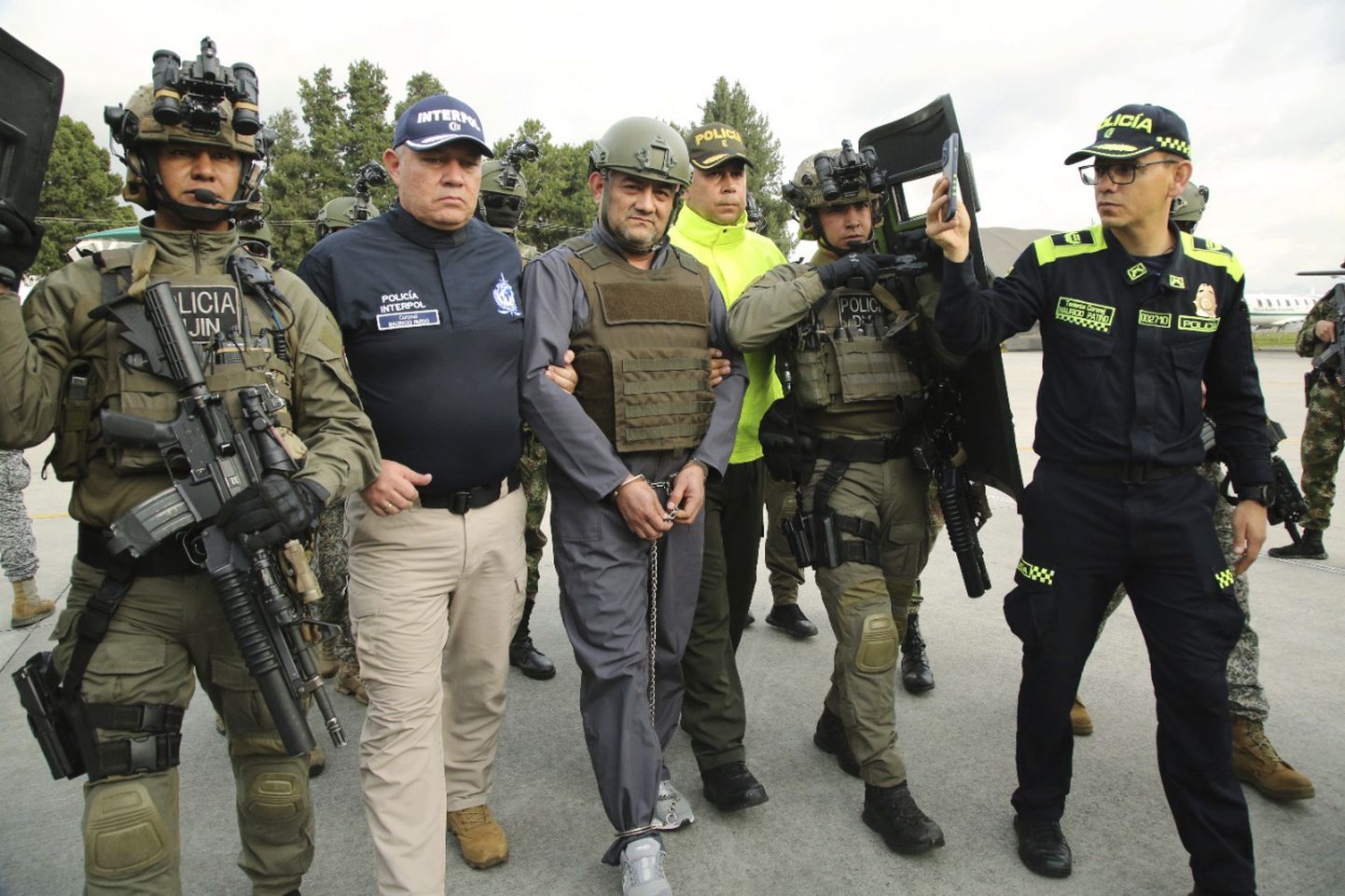 Colombia presidendi kantselei pressiteenistuse fotol eskordivad politseinikud maailma üheks ohtlikumaks narkoparuniks peetavat Dario Antonio Úsugat hüüdnimega "Otoniel" sõjaväelennuväljale, kus andsid ta üle Ühendriikide uimastivastase võitluse ameti (DEA) ametnikele.
