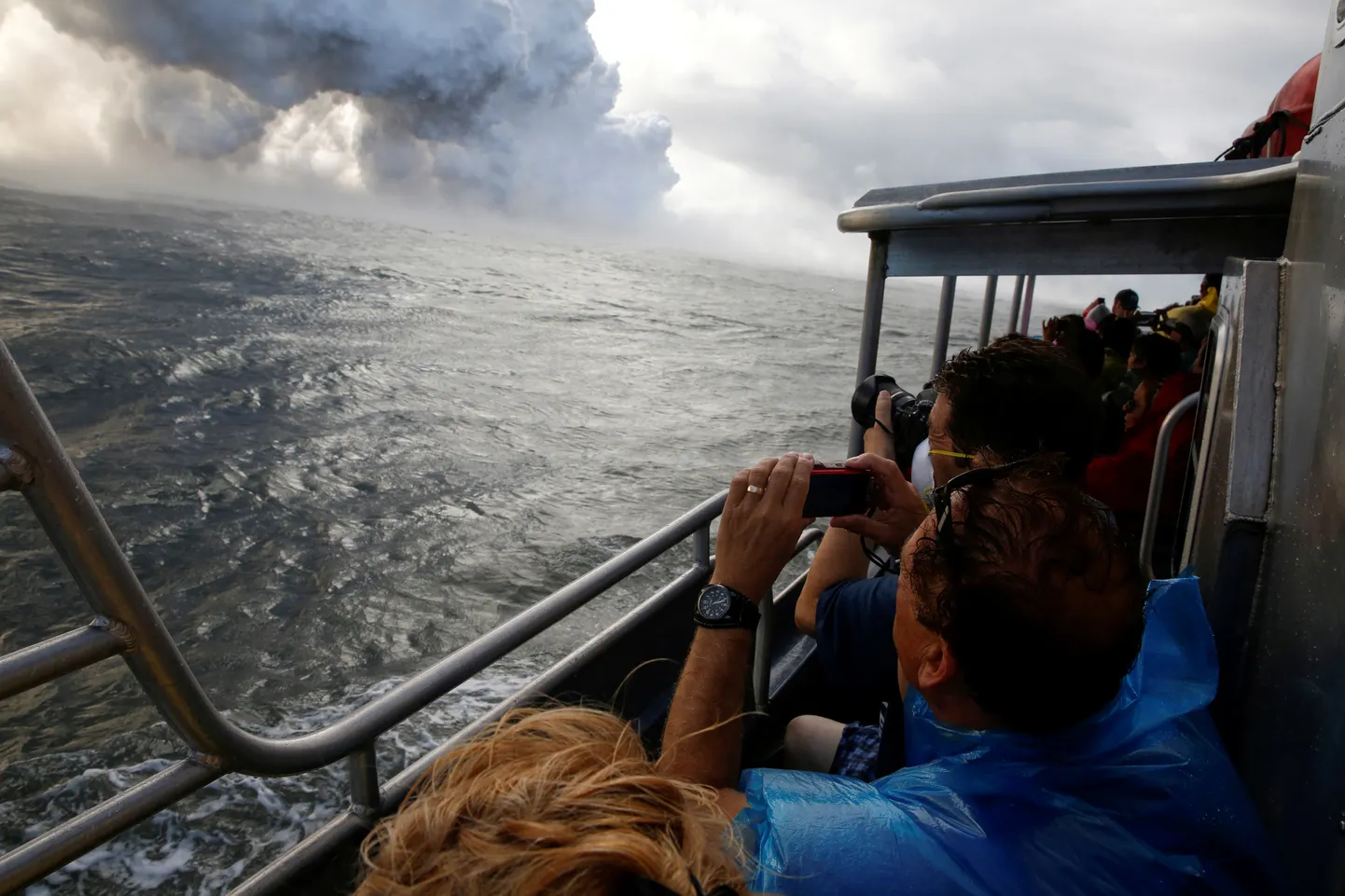 Turistid vaatamas paadilt, kuidas laava voolab Kilauea vulkaanist Vaiksesse ookeanisse Kapoho piirkonnas.