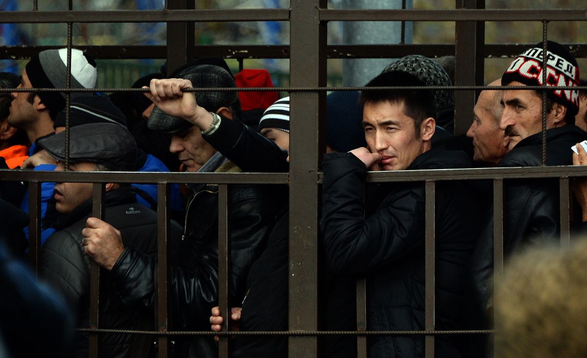 Мигранты из Центральной Азии в очереди на получение разрешения на работу во дворе Федереальной миграционной млужбы в Москве. 