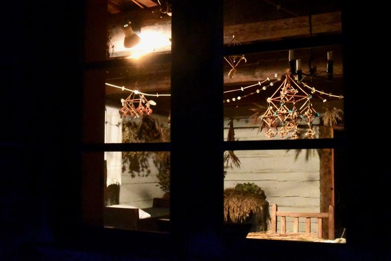 В окнах курземского двора видны традиционные украшения дома - пузури.