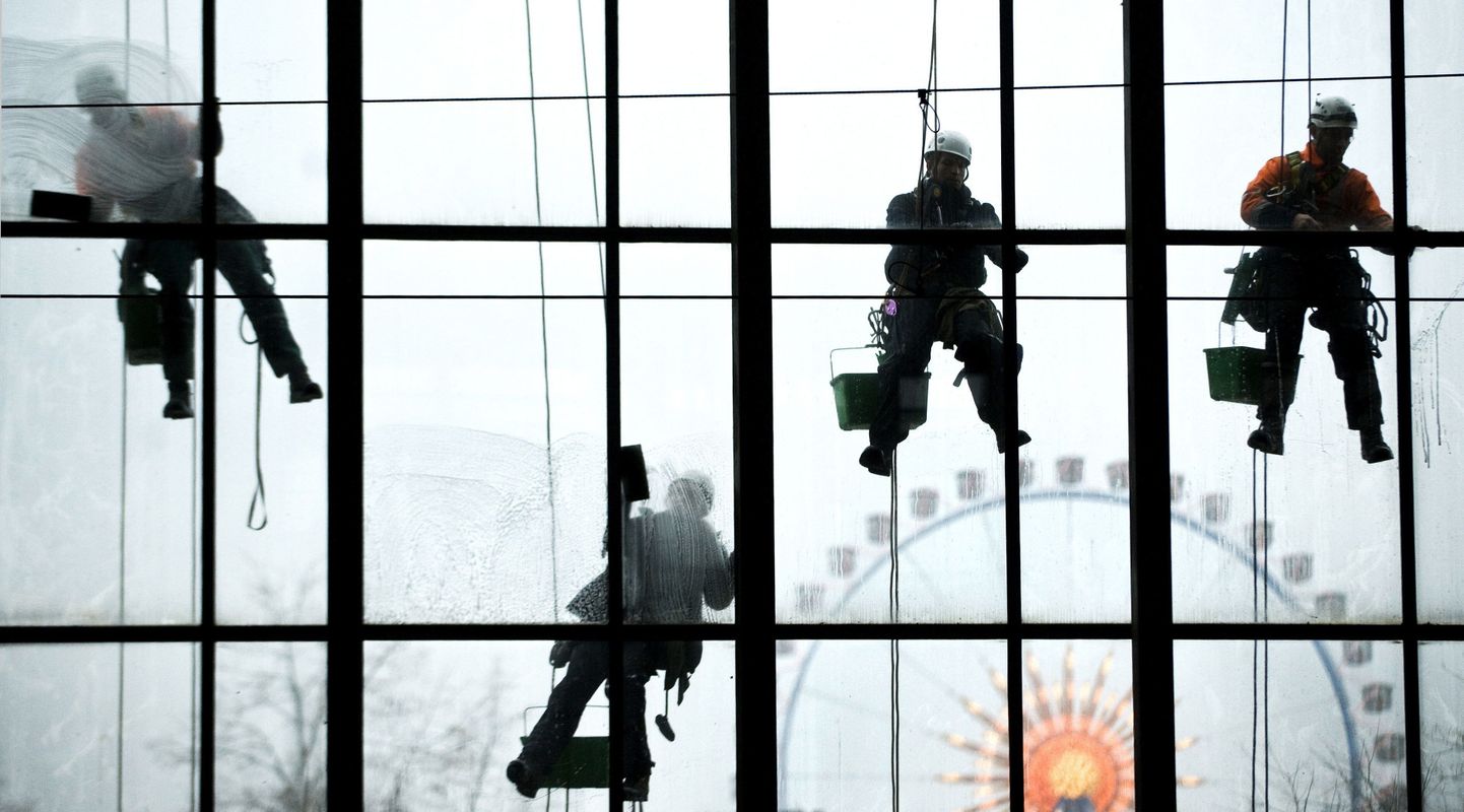 Need Berliini Alexanderplatzi servas aknaid pesevad töölised on end vabatahtlikult üles riputada lasknud.