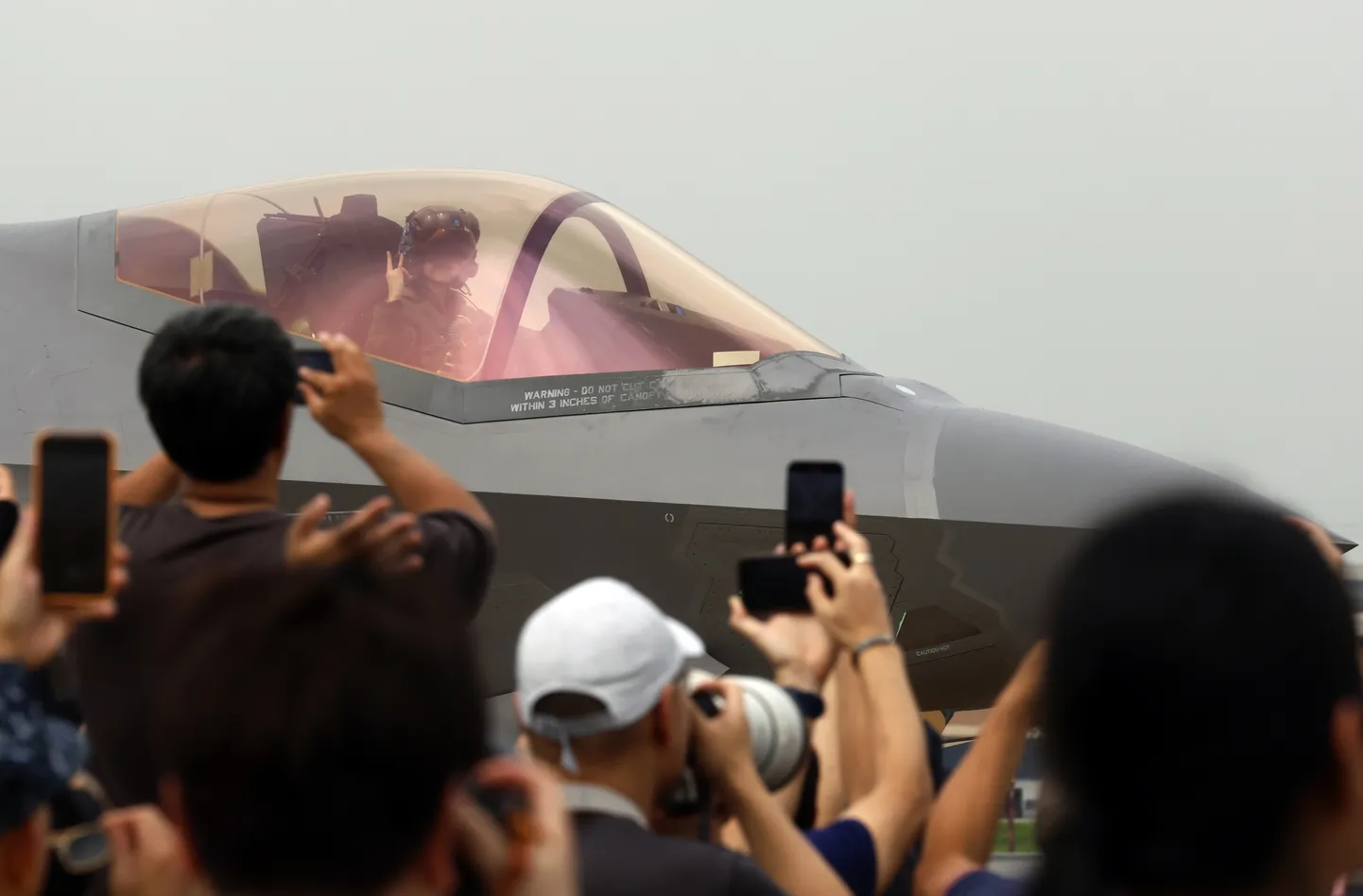 ASV Gaisa spēku lidmašīnas F-35A Lightning II demonstrācijas grupas komandiere un pilote Melānija Klūsnere sveic pūli pēc uzstāšanās par godu Taizemes Karalisko gaisa spēku 88. gadadienai Taizemes Karalisko gaisa spēku bāzē Bangkokā, Taizemē, 2025. gada 7. martā.