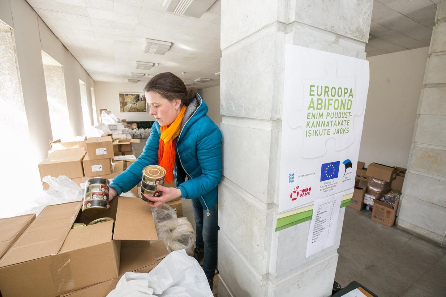 Süda-Eesti sotsiaaltöökeskuse abiline Eneken Savi pakib toiduained kastidesse valmis, et abisaajail oleks hea kogu komplekt korraga kaasa võtta.