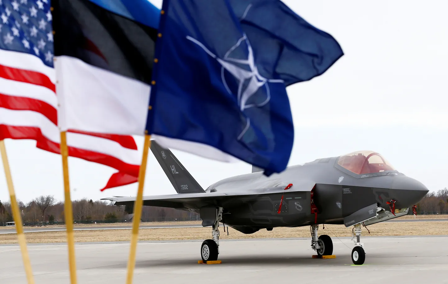 Eesti ja NATO lipud USA hävitaja taustal Ämari lennuväebaasis.