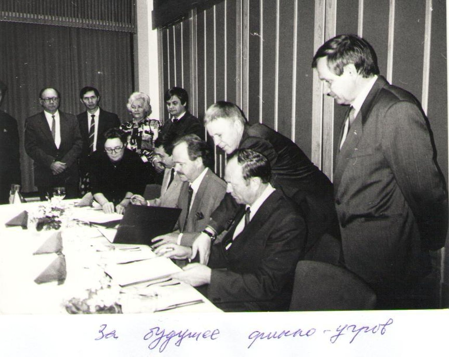 Jäädvustus 1992. aasta veebruari hetkest, mil sõlmitakse koostööleping, mis paneb aluse soome-ugri rahvaste maailmakongressi korraldamisele ja soome-ugri rahvaste assotsiatsiooni asutamisele. Fotol paremalt esimene on komi rahva kongressi liider Valeri Markov, kellest saab pikaaegne soome-ugri rahvaste konsultatiivkomitee esimees. Tema ees istub Mihhail Šiškin, udmurdi rahva kongressi esimees ja hilisem soome-ugri rahvaste assotsiatsiooni esimees.