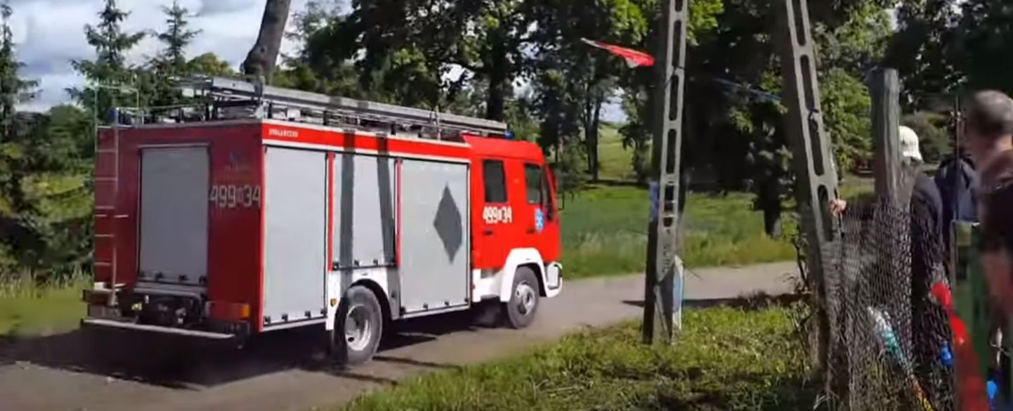 Tuletõrjeauto sõitmas Poola ralli kiiruskatse rajale ja seda kihutavate ralliautodega võrreldes vastassuunas.
