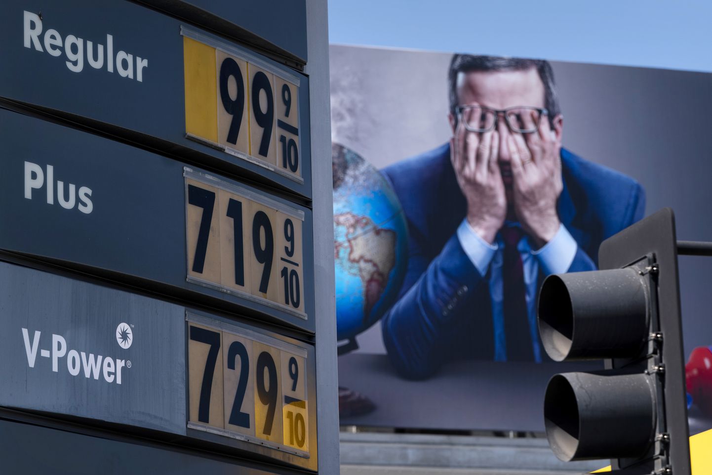 Los Angelese ülikõrged bensiinihinnad 7. märtsil 2022 teleseriaali «Last Week Tonight» reklaamiplakati taustal.