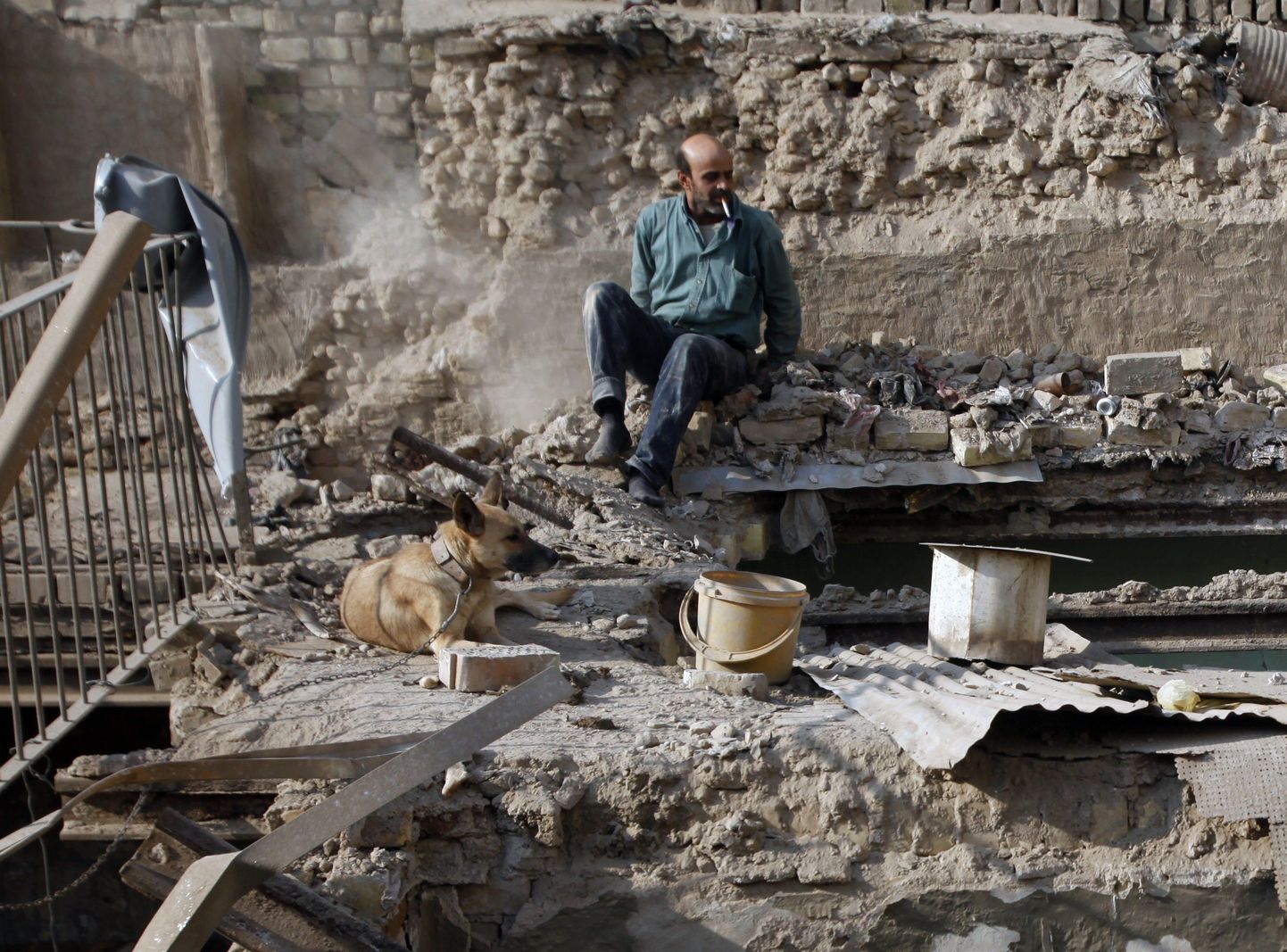 Farouq Omar Muhei oma maja varemetel koos koeraga