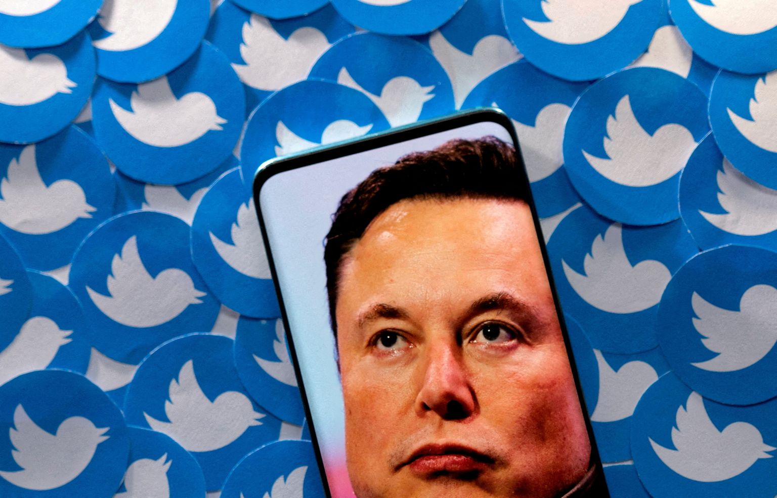 Elon Muski foto nutitelefonid Twitteri logode taustal