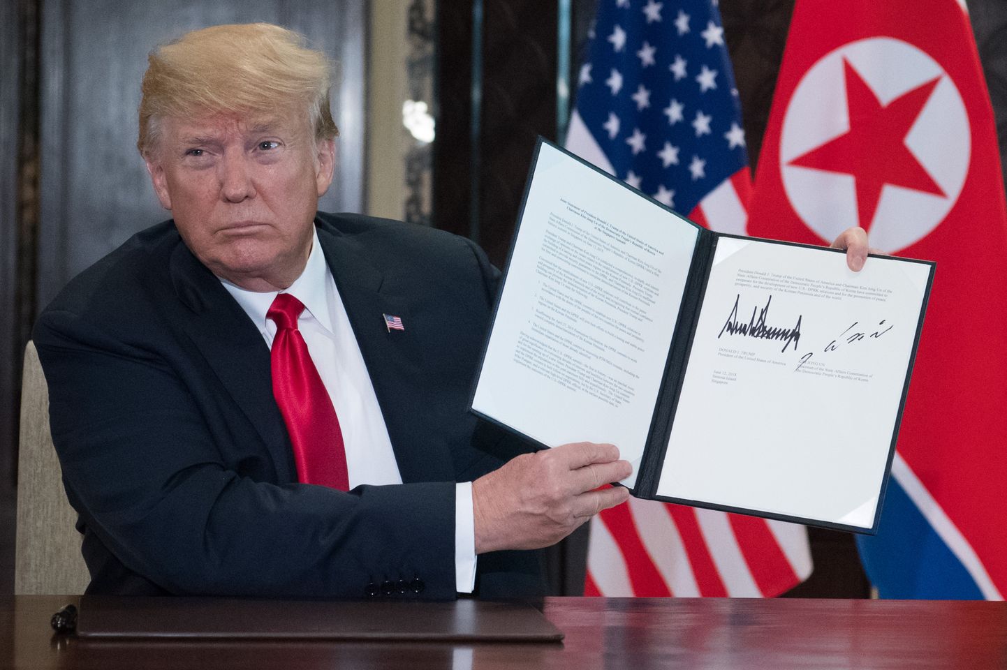 Donald Trump Kim Jong-uniga allkirjastatud dokumenti hoidmas.