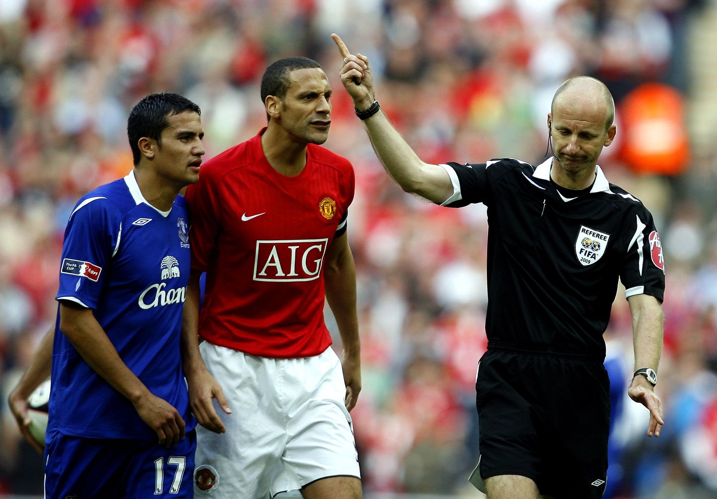 Soome - Eesti mängul kohtunike vaatlejana töötav Mike Riley (paremal) 2009. aastal Premier League'i kohtumist vilistamas. Kohtunikult pärivad aru Tim Cahill (Everton) ja Rio Ferdinand (Manchester United).